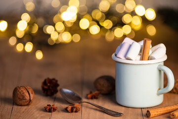 cup of hot chocolate  with marshmallows  cinnamon sticks  cones and branches of spruce. the concept of cozy Christmas and New Year holidays