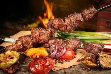 Shashlik or shish kebab preparing on barbecue grill over hot charcoal. Grilled pieces of pork meat...