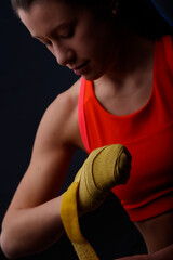 Woman wrapping her fists with yellow hand wraps