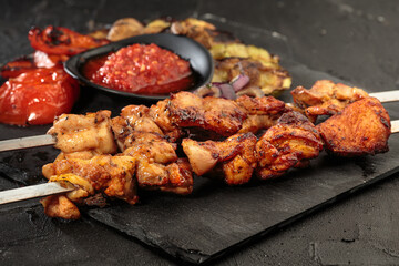 Shashlik or shish kebab preparing on barbecue grill over hot charcoal. Grilled pieces of pork meat on metal skewers.