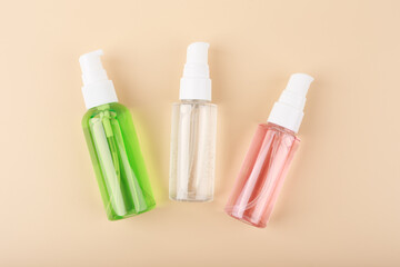 Three different face lotion, liquid foam or gel for skin cleaning in transparent tubes on bright pastel beige background