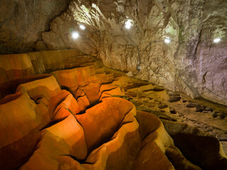The interior of Stopica cave with tufa bathtubs illuminated with colored light, is located on the...