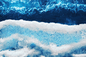 formula of water written on a beautiful textile cover of a glass transparent bottle against a background of ice and blue clear water. ecology. clean. icy. thirst. drinking water.