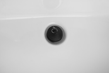 Detail of rubber bath plug. Drainage rubber stopper on white sink