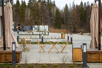An empty outdoor cafe with wooden furniture