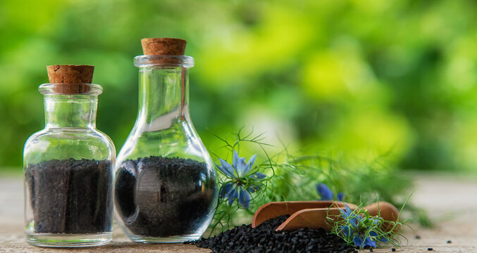 Black cumin oil in a bottle. Selective focus.