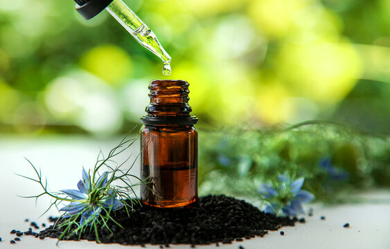 Black cumin oil in a bottle. Selective focus.