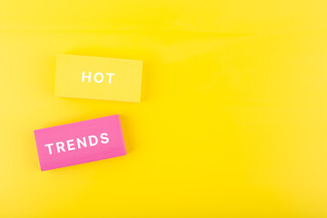 Hot trends written on colorful rectangles on light yellow background with copy space