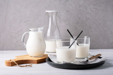Composition of glass serving vessels with milk. Healthy and dietary food, dairy products. Selective focus.