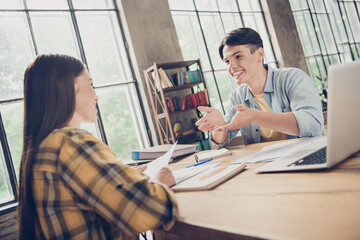 Photo of girl and boy classmates university students talking together relaxing in library preparing for exam test use computer