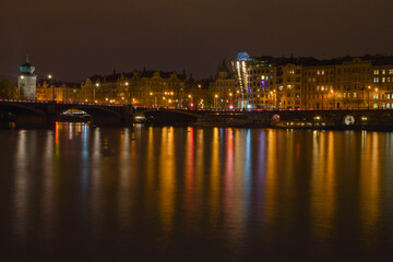 Night city with river, street lights are reflected in the water surface