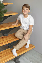 Minimalistic studio photo of eight old caucasian boy wearing in white t-shirt and beige pants for creating mockups for presentation graphic tees and pattern design