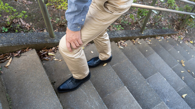 階段で膝が痛む男性