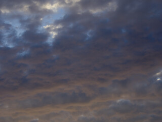 Dramatic cloudscape at sunset. Fancy clouds in the sky. Twilight heaven with orange light.