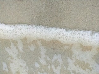 Image of a sandy beach with waves on the sea