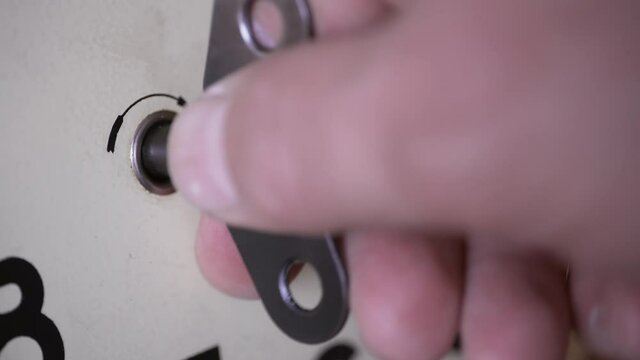 Antique wall mechanical clock. Man winds a clockwork with a winding key. Close-up of winding up an old clock. Video contains the sound.