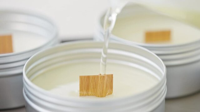 Close up of melted soy wax gets poured into small cans diy candle shot in 4k super slow motion