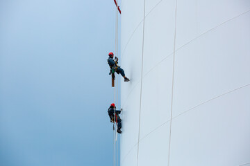 Male two workers down height tank rope access inspection of thickness shell plate storage tank gas propane