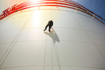 Male workers control rope down height tank rope access inspection of thickness shell plate storage...