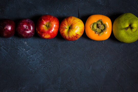 Set of colourful fruits on a dark moody painted background with copy space at the bottom
