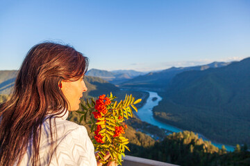 Travel and tourism. A girl of athletic build on a beautiful river bank on the frn of the Altai Mountains enjoying nature