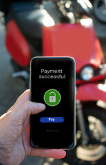 Man's hand pays the rental of electric motorcycle with application on his phone