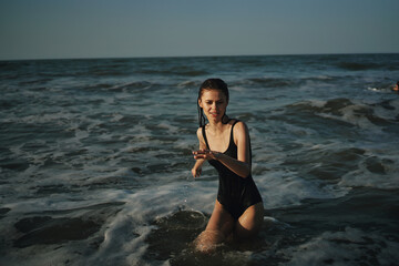 Cheerful woman black swimsuit ocean nature summer tan