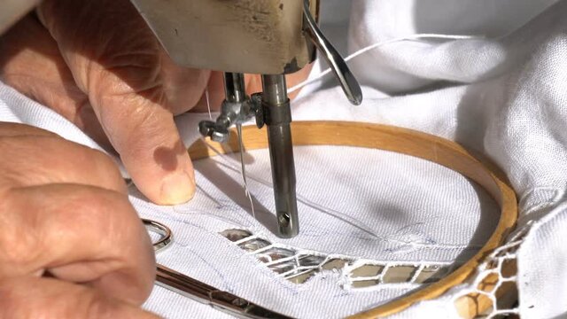 An Old Woman is Working with a Sewing Machine
