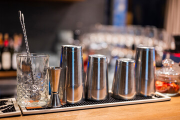 bar equipment on the bar counter, shaker, mixing glass and bar spoon