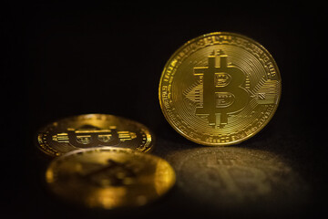 Golden bitcoin symbolic coins on black background