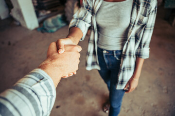 Fototapeta na wymiar Close up mixed race couple hand shaking after long day of work