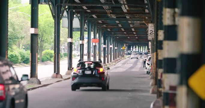 A 4K of the cars driving under elevated train tracks in the Bronx