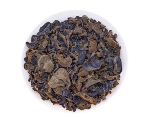 Dried Auricularia mushrooms lie on a round, white plate. An isolated object on a white background. High quality photo