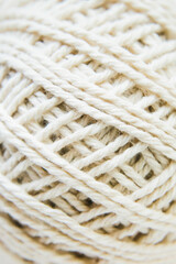 Texture of beige woolen threads, close-up, top view. Sewing and needlework concept. Macro. Selective focus.