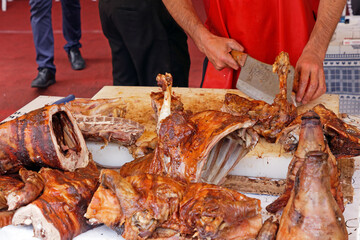 Cutting meat of lamb baked on a spit