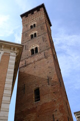 Fototapeta na wymiar Medieval tower. Trojan Tower of Asti.The tall tower, also known as the clock tower, is built in red terracotta bricks. Asti, Piedmont, Italy.