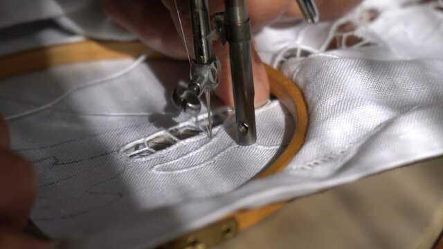An Old Woman is Working with a Sewing Machine
