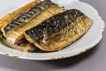 Fried mackerel with a short body file or Platoo in Thai is served on a white porcelain plate on a...