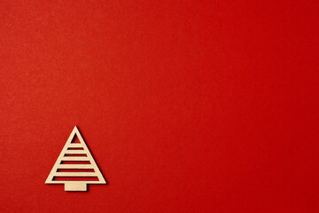 Christmas red background, with wooden Christmas trees. Minimalistic Christmas red background. Christmas background with toys top view on a red background. New Year card.