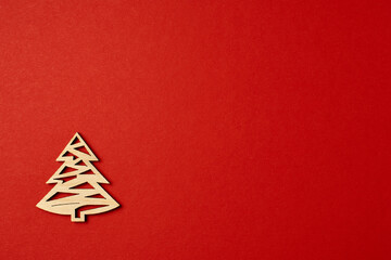 Fototapeta na wymiar Christmas red background, with wooden Christmas trees. Minimalistic Christmas red background. Christmas background with toys top view on a red background. New Year card.