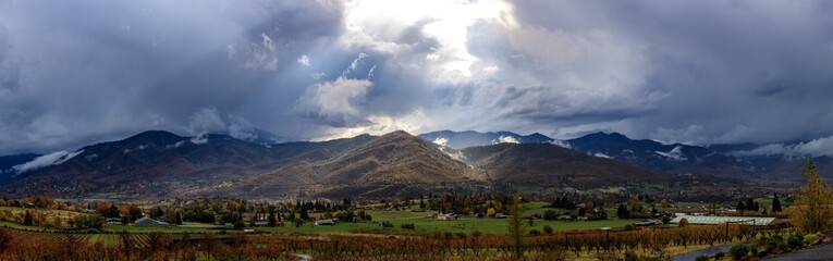 Giant panorama looking acorss a vineyard at the valley of Ashland Oregon with dramatic clouds and lighting