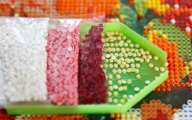 Multicolored diamond strases in container for handmade process of creation of 3D painting