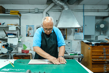 Crop artisan folding book cover in printing workshop