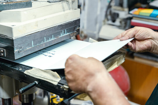 Crop faceless worker printing on machine