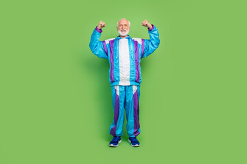 Photo of funky cool senior man wear sportive suit showing biceps smiling isolated green color...