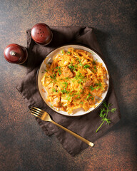 Braised cabbage. Stewed cabbage or bigos with turkey meat in a ceramic plate on a dark background. Traditional Polish dish	