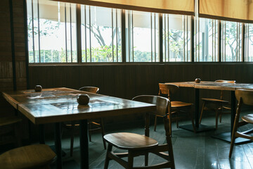 Wooden table and chair in the restaurant near the windows