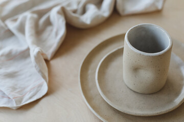Beige ceramic plate on a wooden table top view. minimalist handmade ceramic tableware and pottery.
