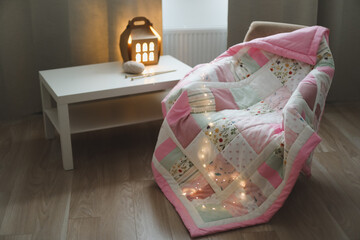Cozy homely background with wool yarn and knitting needles on an armchair with a blanket. - obrazy, fototapety, plakaty