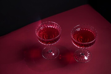two wine glasses on a black background. a stylish, tempting offer advertising red wine. a place to copy. wine list. restaurant advertising. romantic dinner. a bright combination of red and black.